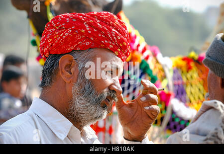 Porträt von einem nicht identifizierten Rauchen Rajasthani indische Mann besucht das Pushkar Fair, Indien Stockfoto