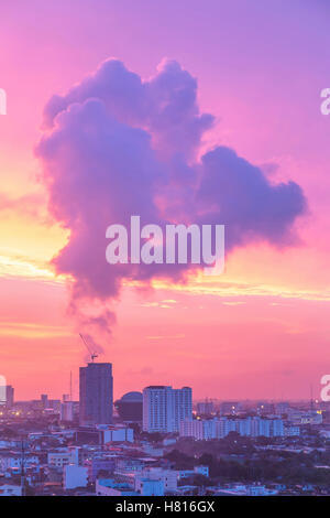 Seltsame Rauch schwebt über Gebäude in Bangkok während der Dämmerung nach Sonnenuntergang. Stockfoto