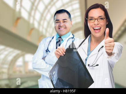 Ärzte oder Krankenschwestern mit Daumen nach oben halten x-ray Standing innen Krankenhaus. Stockfoto