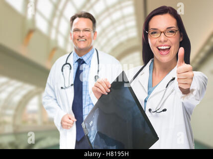 Ärzte oder Krankenschwestern mit Daumen nach oben halten x-ray Standing innen Krankenhaus. Stockfoto