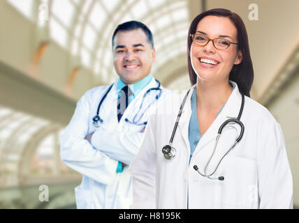 Zwei männliche und weibliche Ärzte oder Krankenschwestern stehen innen Krankenhausgebäude. Stockfoto
