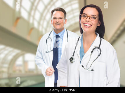 Zwei männliche und weibliche Ärzte oder Krankenschwestern stehen innen Krankenhausgebäude. Stockfoto