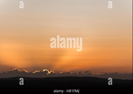 Strahlen der Sonne hinter Wolken wie die Sonne an einem kalten Herbstmorgen angezeigt. Stockfoto