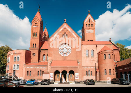 Minsk, Weißrussland. Die Hof-Fassade der römisch-katholische Kirche des Heiligen Simon und Helena oder rote Kirche mit Parkplatz im Sommer sonnige D Stockfoto