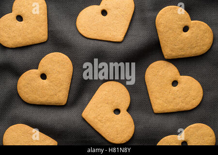 Leckeren Lebkuchenherzen auf dunklen Tischdecke. Ansicht von oben. Stockfoto