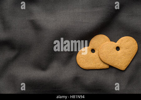 Leckeren Lebkuchenherzen auf dunklen Tischdecke. Ansicht von oben. Stockfoto