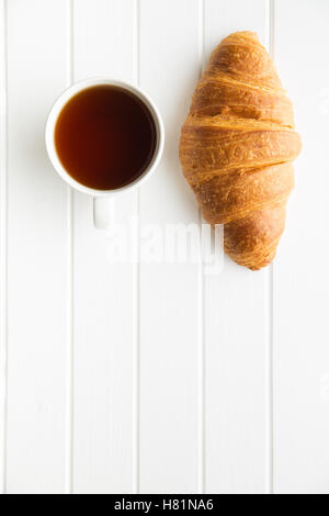 Leckere buttrig Croissant und Tasse Tee. Ansicht von oben. Stockfoto