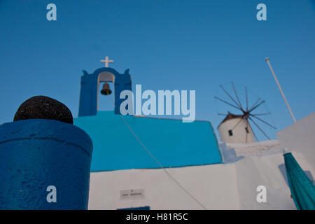 Gebäude, Glocke und eine Windmühle in typischen Farben in Oia, Santorini, Griechenland Stockfoto