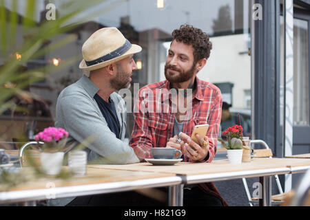 Gay paar Teilen Telefon im café Stockfoto