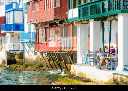 MYKONOS, Griechenland - 2. Oktober 2011: Dorf und Strand-Szene mit wenig Venedig-Häuser, Geschäfte, einheimische und Besucher, ich Stockfoto