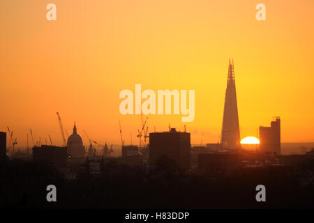 Sonnenaufgang hinter dem Shard, London, mit St. Pauls Cathedral und zahlreichen Baukräne, die am Horizont silhouettiert wurden Stockfoto