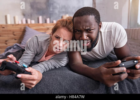 Amüsiert paar Spielen von Videospielen im Schlafzimmer zusammen Stockfoto