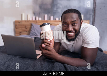 Fröhlichen Mann, der Kaffee im Schlafzimmer Stockfoto