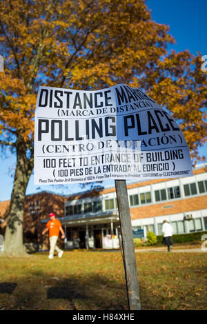 Merrick, New York, USA. 8. November 2016. Am Wahltag Bewohner kommen aus, und gehen, zum Wahllokal für Präsident und staatlichen und lokalen Behörden zu stimmen. Entfernung Marker Zeichen auf Holzpfosten heißt, in Englisch und Spanisch, es 100 Fuß zum Eingang der Polling-Ort an der Park Avenue Elementary School. Stockfoto