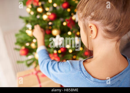 Kleine Mädchen schmücken Weihnachtsbaum Stockfoto