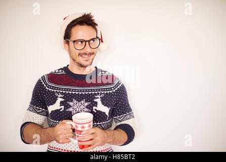 Mann mit heißer Schokolade stand vor Wand Stockfoto