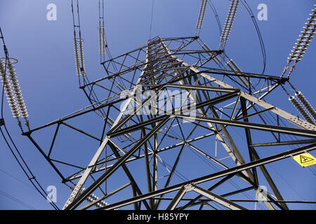 Strommast gegen einen klaren, blauen Sommerhimmel, fotografiert von unten aussehen Stockfoto