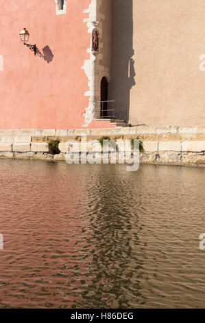 Reflexion von den Wänden der Kirche Église Sainte Marie-Madeleine in den Gewässern von Kai Marceau, Provence, Frankreich Stockfoto