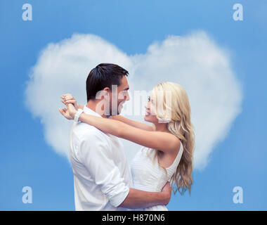 glückliches Paar umarmt Herz geformte Wolke Stockfoto