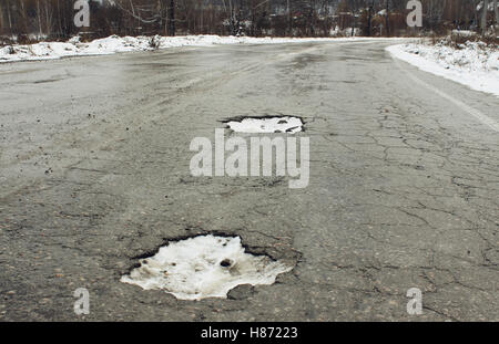 Große Grube auf der alten Straße im winter Stockfoto