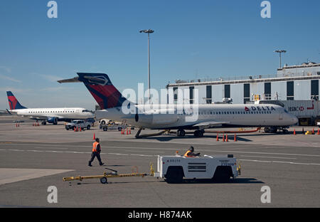 Flughafen JFK New York USA - Passagierjets auf einem terminal Stand und einen Schlepp-Schlepper mit Flughafen Arbeiter Stockfoto