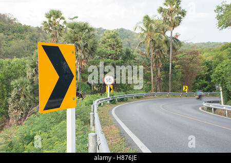 Kurve-Straße und rechts drehen Signal und Tempolimitschilder auf dem Weg bergab, AF fokussiert Stockfoto