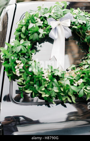 Kranz gemacht Grün liegt auf schwarzes Auto Stockfoto