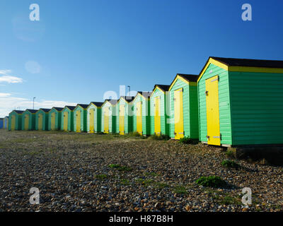 Grün und gelb lackierten Strandhütten in Littlehampton, West Sussex. Stockfoto