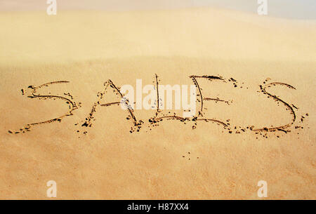 Verkauf-Hinweis auf den Sand geschrieben Stockfoto