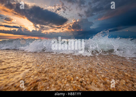 Bunte Strand Ziel Sonnenaufgang oder Sonnenuntergang mit schönen brechenden Wellen Stockfoto