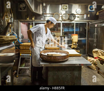 Wagashi. Ein Mann, eine große Schale mit Zutaten mischen und den gemischten Teig in Formen Pressen Stockfoto