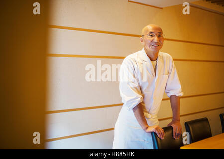 Ein Koch, ein Itamae oder Meister Sushi-Koch tragen weiße Jacke und Schürze. Stockfoto