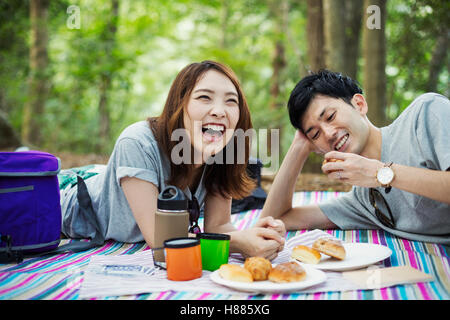 Junge Frau und Mann mit einem Picknick im Wald. Stockfoto