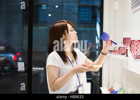 Verkäuferin in einem Laden verkaufen Edo Kiriko schneiden Glas in Tokio, Japan. Stockfoto