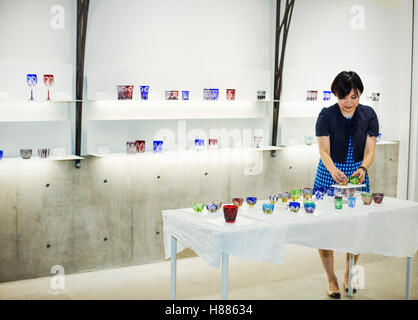 Verkäuferin in einem Laden verkaufen Edo Kiriko schneiden Glas in Tokio, Japan. Stockfoto