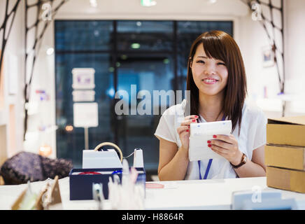 Verkäuferin in einem Laden verkaufen Edo Kiriko schneiden Glas in Tokio, Japan. Stockfoto