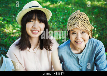 Porträt einer lächelnden senior Frau trägt einen Hut häkeln und eine junge Frau mit einem Panama-Hut. Stockfoto