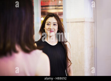 Porträt einer lächelnden jungen Frau mit langen braunen Haaren. Stockfoto