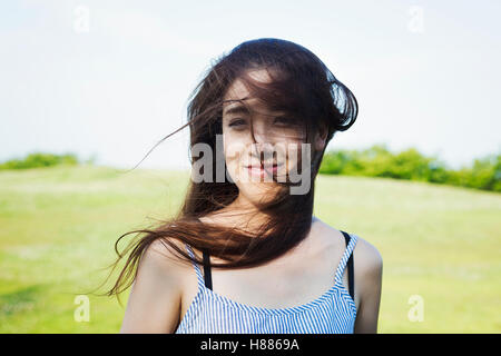 Porträt einer lächelnden jungen Frau mit langen braunen Haaren. Stockfoto