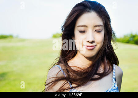 Porträt einer lächelnden jungen Frau mit langen braunen Haaren. Stockfoto