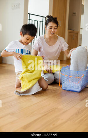 Haus der Familie. eine Frau und ihr Sohn sortieren und sauberen Wäsche Falten. Stockfoto