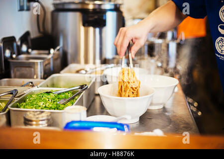 Eine Ramen Noodle Shop Küche. Ein Koch, Schalen von Ramen-Nudeln in Brühe, eine Spezialität und Fast-Food-Gericht vorbereiten. Stockfoto