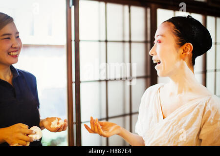 Eine Geisha oder Maiko mit Friseur- und Make-up-Künstler erstellen die traditionelle Frisur und Make up. Stockfoto