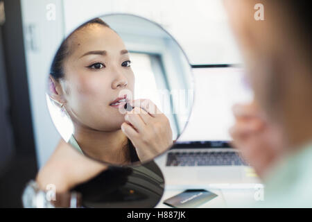 Eine Geschäftsfrau, Vorbereitung für die Arbeit, Lippenstift und einen Spiegel. Stockfoto