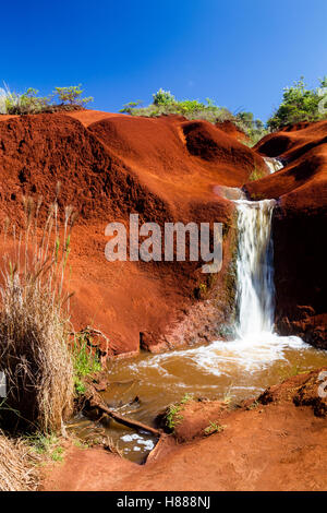 Ein kleiner Wasserfall Graben durch rote Erde in der Waimea Canyon auf Kauai, Hawaii, USA. Stockfoto