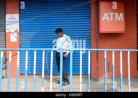 Kolkata, Indien. 9. November 2016. Bank-Angestellter zu überprüfen sein Handy vor engen Bank. Geschäft erfolgt überall in Indien als Regierung der Union Ankündigungen eines Tages Bank und ATM heruntergefahren um die Nation aufgrund von Rs. 500 und Rs. 1000 Banknoten bundesweit zurückzuziehen. © Saikat Paul/Pacific Press/Alamy Live-Nachrichten Stockfoto