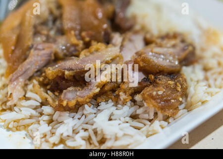 Geschmorte Schweinskeule auf Reis mit Knoblauch und Kohl in der Draufsicht Stockfoto