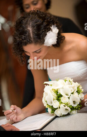 Standesamtliche Trauung, Braut, die Unterzeichnung einer Heiratsurkunde beim Standesamt Stockfoto