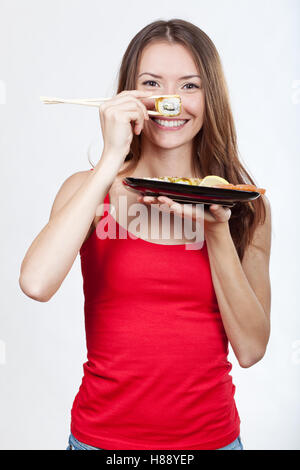 schöne Brünette Frau Holding sushi Stockfoto