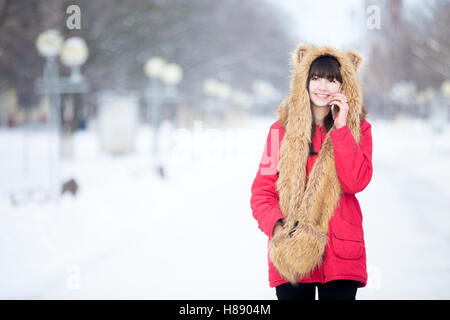 Junge Frau am Telefon im Freien im Winter Stockfoto